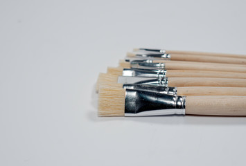 New wooden paint brushes set on light background