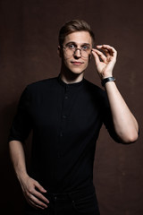Man in round glasses and a black shirt.