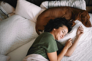 Girl with dog in bed. Best friends sleeping together.