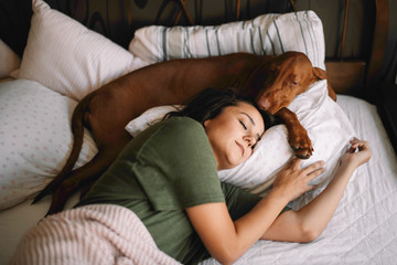 Girl with dog in bed. Best friends sleeping together.