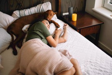 Girl with dog in bed. Best friends sleeping together.