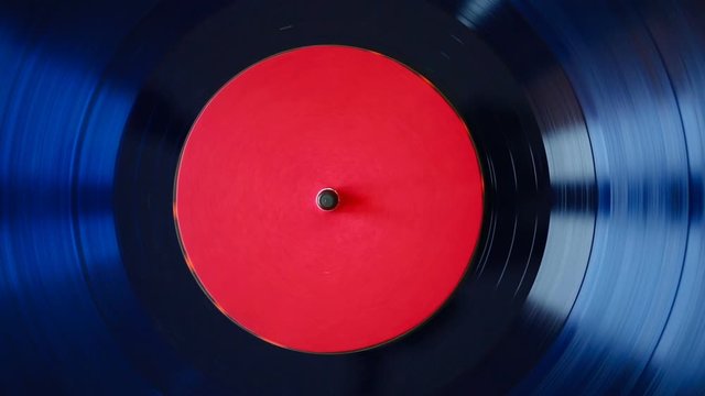 Spinning vinyl record. Close up of blue turntable vinyl record playing