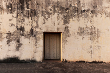 old yellow wooden door in a dirty wall india