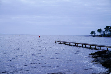 sunset empty pontoon sunrise blue water winter on Lake Hourtin in Gironde france
