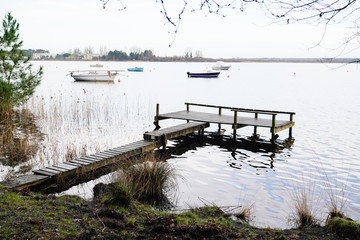 little sailboats at the Lake in Sunrise aside wooden pontoon jetty in morning day
