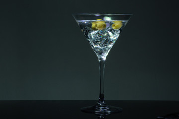 Long exposure martini glass with ice and olives
