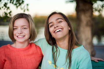 Two smiling girls. Two friends. Happy female students having fun together. Two young girls in the evening outside 