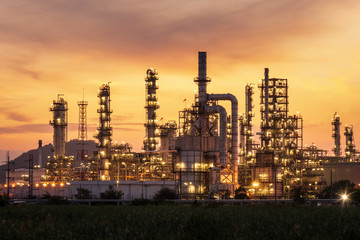 Fototapeta na wymiar oil refinery and natural gas storage tank at yellow sunrise