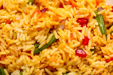 Tasty rice pilaf with vegetables as background, closeup