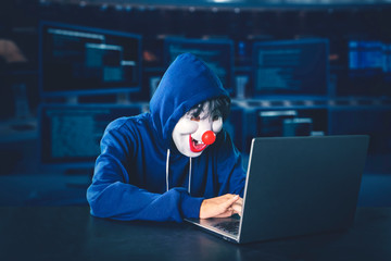Hacker wearing clown mask working
