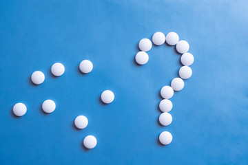 Question mark white pills on blue background. Medicine science. Cure concept. Question mark icon. Medicine pill.