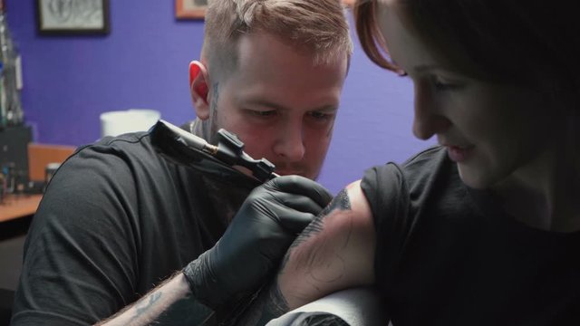 Tattooer getting tattoo of snake in salon, process