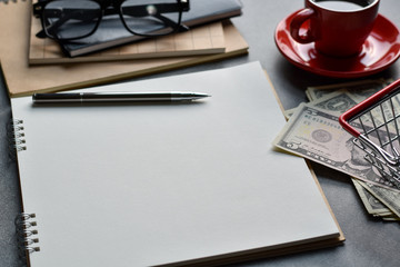 Blank paper for writing business ideas, Close-up view table desk with pen, glasses, black coffee and money.