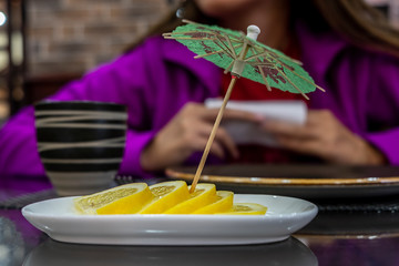 Lemon lobules with umbrella toothpick. Tea time. Selective focus.
