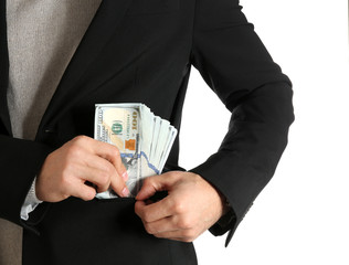 Man putting bribe money into pocket on white background, closeup