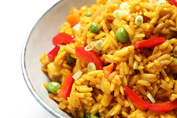 Delicious rice pilaf with vegetables on white background, closeup