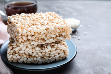 Delicious rice crispy treats on grey table, closeup