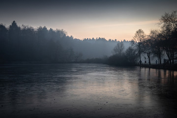 Fototapeta premium beautiful view on a frozen lake in winter season in beautiful sunset and mountains