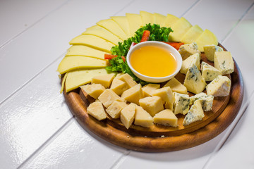 Delicious cheese on the table with honey and vegetables