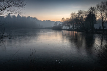 beautiful view on a frozen lake in winter season in beautiful sunset and mountains