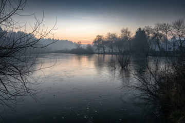 beautiful view on a frozen lake in winter season in beautiful sunset and mountains