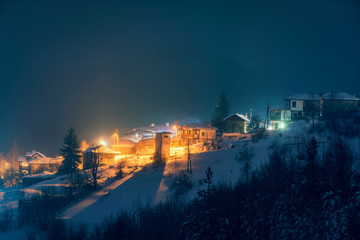 Fototapeta premium Small village in the snowy mountains in winter night