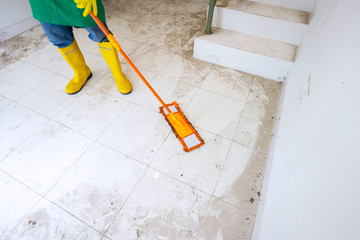 Professional cleaner mopping dirty floor