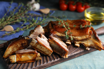Delicious roasted ribs served on light blue wooden table, closeup