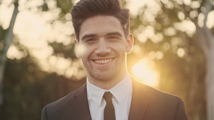 Close up view of cheerful handsome businessman looking at the camera outdoors