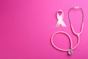Pink ribbon as breast cancer awareness symbol and stethoscope on color background, flat lay. Space for text