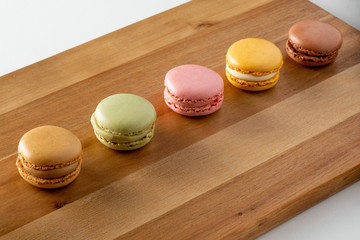 delicious multi flavor Macarons over wooden board with space for text