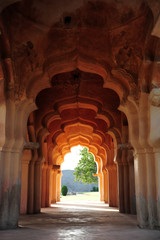 Intricate carvings on the arched hallway Lotus Mahal Temple in Hampi, Karnataka, India. Beautiful carved stone arch. Popular tourist place.