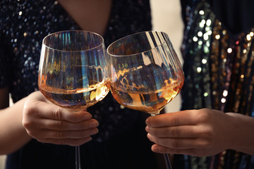 Women clinking glasses with white wine, closeup