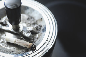 cigarette on an ashtray on a dark background