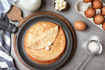 Flat lay composition with thin pancake on grey table