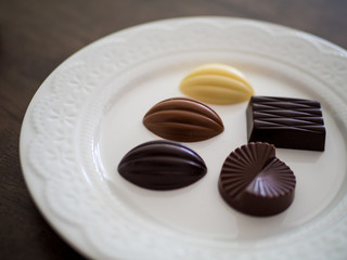 白いお皿の上に並べられた様々な種類のチョコレート