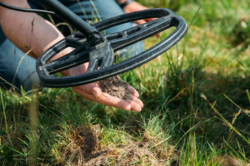 Metal detector searching for treasure in the ground.