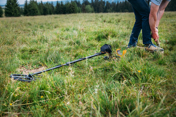 Metal detector searching for treasure in the ground.