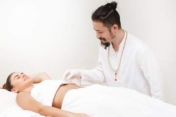 Oriental medicine doctor doing acupuncture stomachs to relieve a woman's stomach pain. Alternative...