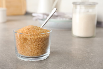 Glass bowl with brown sugar on grey table