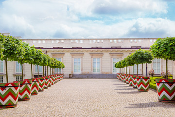 Fototapeta premium Castle gardens in front of Royal Castle in Warsaw, saxon facade Poland. Landscape design, park with shrubs and green lawns.