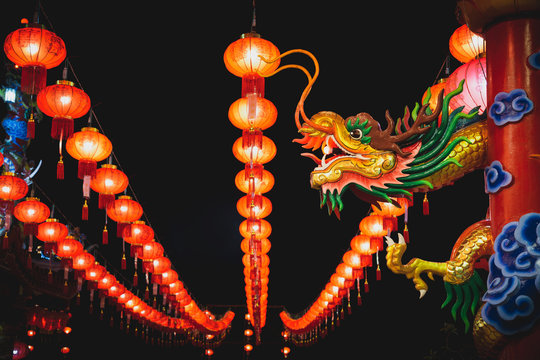 The dragon head sculpture on the post with Chinese lanterns at night. Chinese New Year