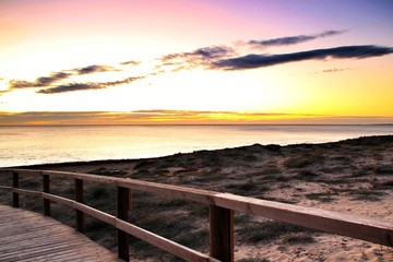 Wooden walkway to the beach at sunrise in Alicante, Spain