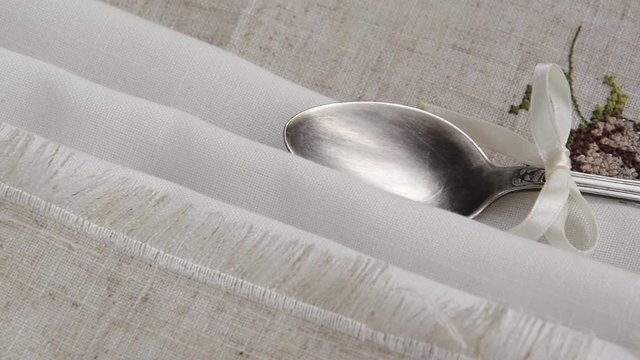Vintage russian silverspoon with silk ribbon on linen napkin. Old fashion heroloom silverware