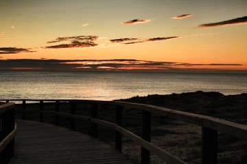 Fototapeta premium Wooden walkway to the beach at sunrise in Alicante, Spain