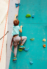 Little boy on rock climbing on the wall in the sport park