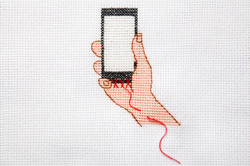 Embroidery on the dependence of people on the phone. Smartphone sewn to hand.