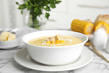 Delicious corn cream soup served on white marble table indoors
