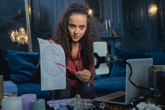 Focused young lady showing her astrological forecast