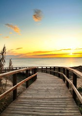 Obraz premium Wooden walkway to the beach at sunrise in Alicante, Spain